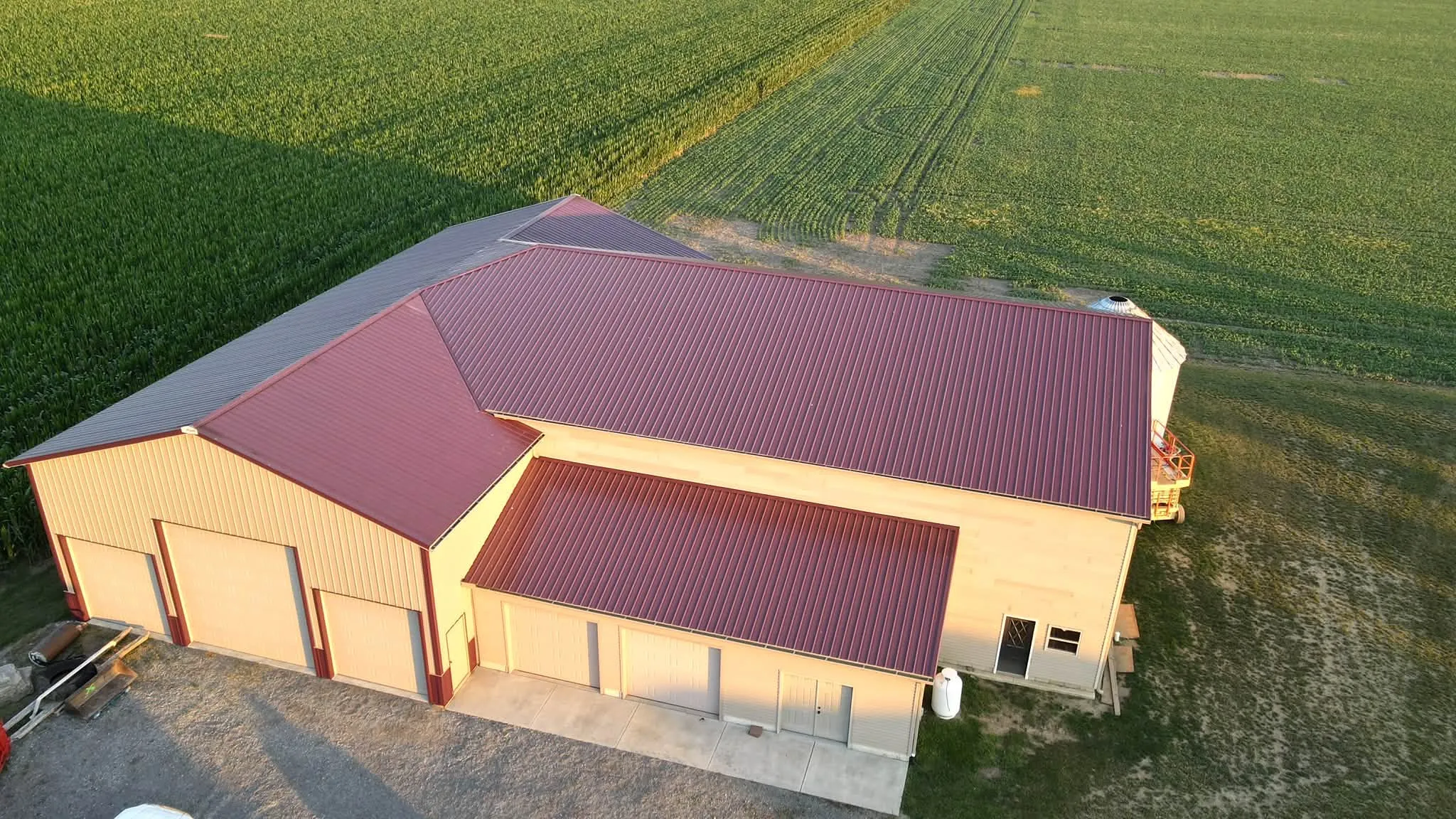 Burgundy and tan pole barn beside an Ohio cornfield